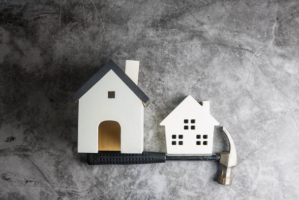 Ξύλινο λευκό σπίτι παιχνίδι και εργαλεία κατασκευής σε γκρι-μαύρο τσιμέντο φόντο δαπέδου με αντίγραφο χώρου.Real estate concept, Νέο σπίτι.Home concept επισκευής - Φωτογραφία, εικόνα