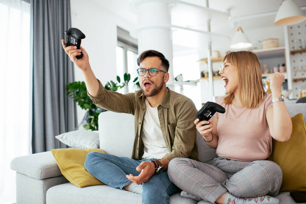 couple jouer à des jeux vidéo à la maison  - Photo, image