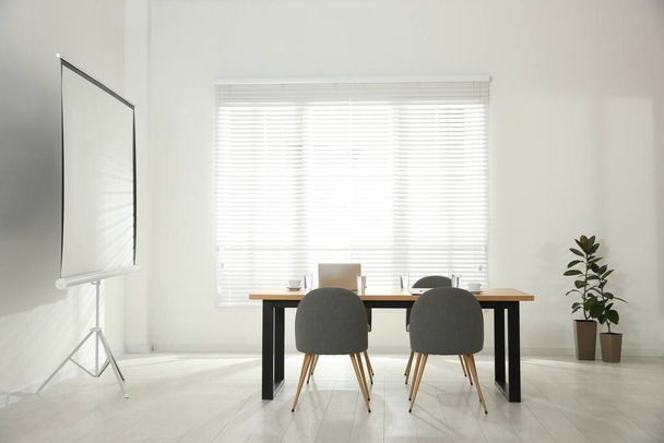 Conference room interior with wooden table and video projection screen - Foto, immagini