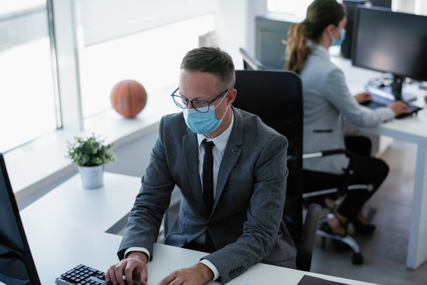 Handsome businessman with medical mask. Young businessman working in office. - Foto, afbeelding