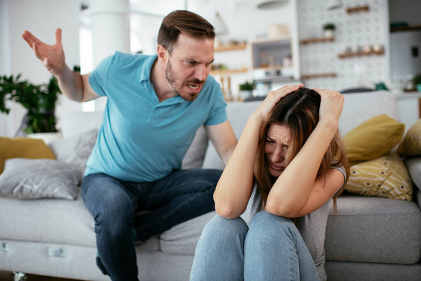 Gewalt in der Familie. Mann schlägt und schreit Ehefrau an. - Foto, Bild