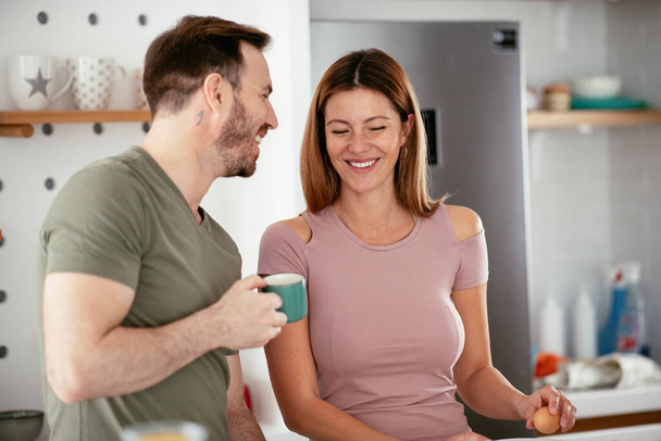 Rakastava pari juo kahvia valmistettaessa aamiaista. - Valokuva, kuva