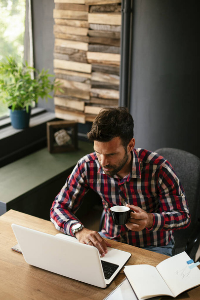 Jeune homme d'affaires travaillant sur un ordinateur portable au bureau. Homme d'affaires travaillant sur un nouveau projet - Photo, image