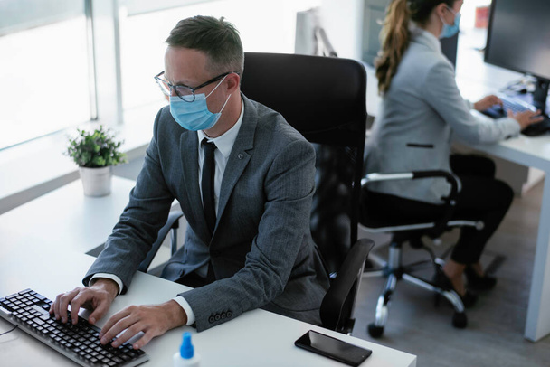 Handsome businessman with medical mask. Young businessman working in office. - Fotó, kép