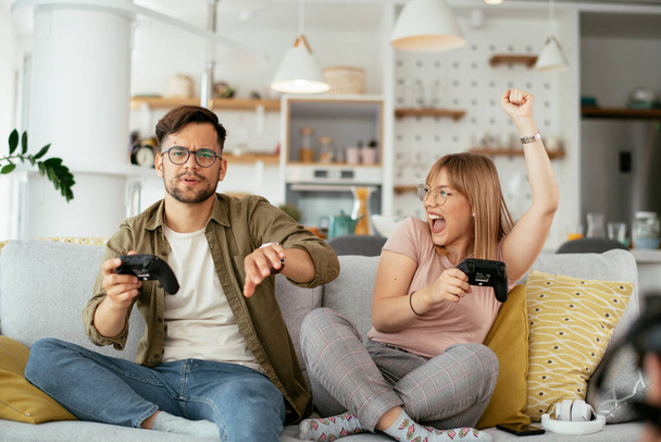 Beautiful young couple playing video games at home. - Foto, immagini