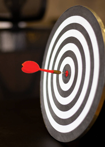 Le jeu de fléchettes a une flèche jetée au centre de la cible de tir pour le ciblage des entreprises. - Photo, image