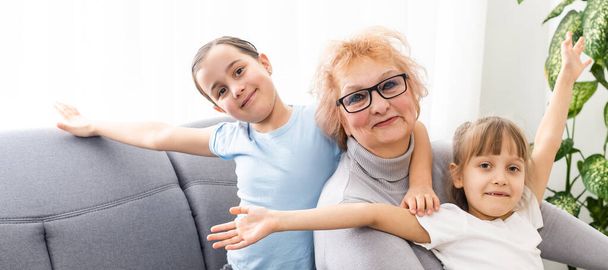 Mutlu orta yaşlı yetişkin büyükanne ve küçük anaokulu çocuğu iki torun evde oynarken eğleniyor. - Fotoğraf, Görsel