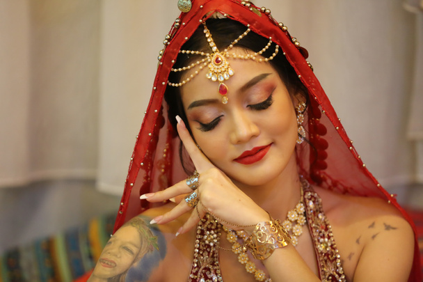 портрет красивой индийской девушки в костюме сари. Молодая индуистка модель с золотым набором ювелирных украшений кундан. Традиционный индийский костюм lehenga choli . - Фото, изображение