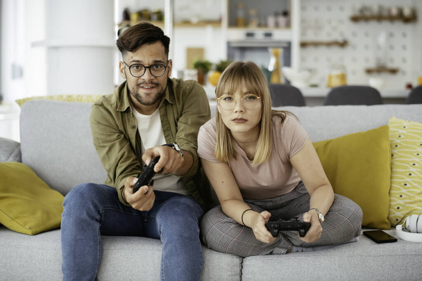 Krásný mladý pár hraje videohry doma. - Fotografie, Obrázek