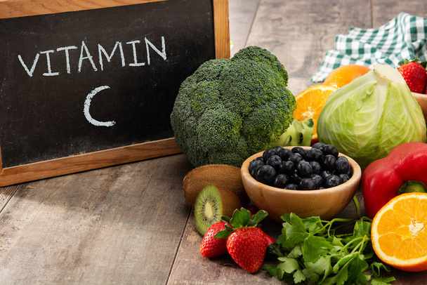 High in vitamin C food and blackboard on wooden table - Photo, Image