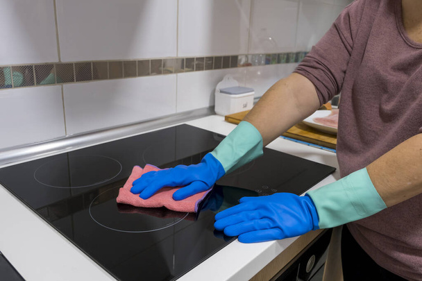 Pulire il tavolo in casa Sanificare la superficie del tavolo da cucina con un flacone spray disinfettante, lavare le superfici con i guanti. COVID-19 prevenzione igienizzazione interna. - Foto, immagini