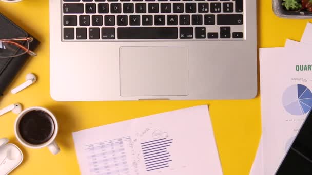 Сучасний офісний жовтий стіл з діловими жінками руками, що показують документи під час відеозапису на ноутбуці крупним планом
  - Кадри, відео