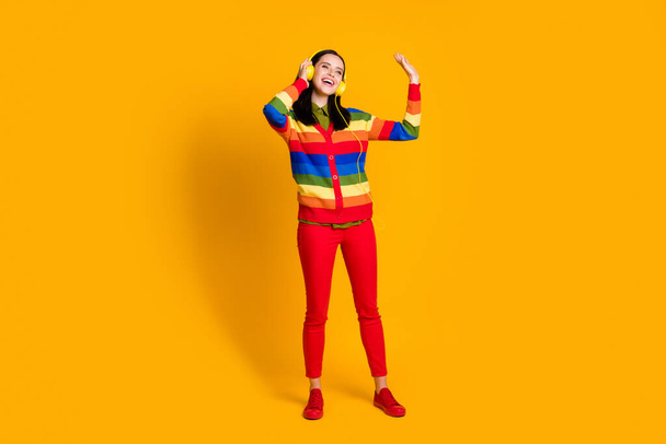 Full body photo of young cheerful girl listen music earphones look empty space isolated over yellow color background - Φωτογραφία, εικόνα
