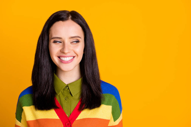 Photo of attractive tricky young woman happy smile look empty space isolated over yellow color background - Foto, Imagem