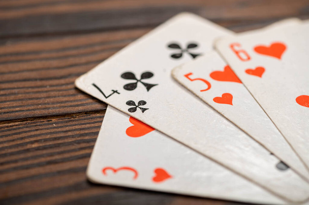 Spielkarten auf einem Holztisch. Nahaufnahme, selektiver Fokus. - Foto, Bild