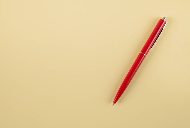 Red pen on an isolated yellow background. - Fotó, kép