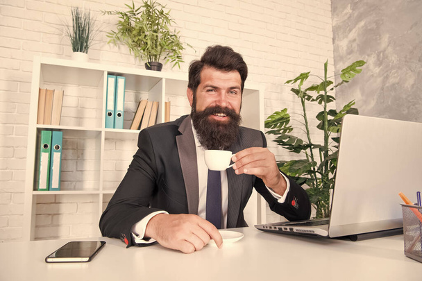 Reception room. Respectable ceo. Man handsome boss sit in office drinking coffee. Comfy workspace. Bearded hipster formal suit relaxing with coffee. Office life is unthinkable without good coffee - Foto, imagen