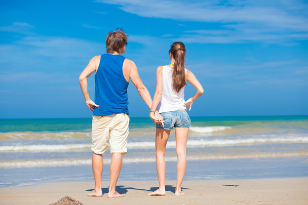Back view of couple holding hands on tropical beach - Foto, Bild