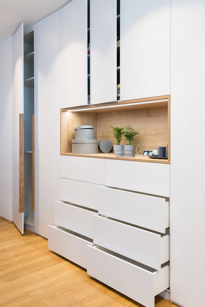 Witte houten kast met open planken in slaapkamer van modern huis - Foto, afbeelding