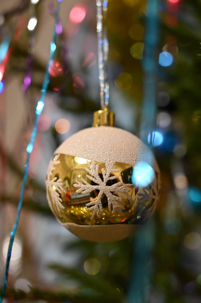 雪の結晶が飾られたクリスマスツリーにぶら下がっている黄金のボール。閉鎖. - 写真・画像