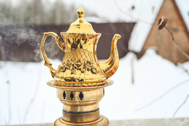 Прекрасний золотий чайник з підігрівом самару. Російська традиційна чайна машина. Приватний сад взимку.. - Фото, зображення