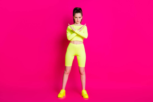 Full size photo of serious sportswoman cross arms show decline signal wear yellow short isolated on bright pink color background - Фото, изображение