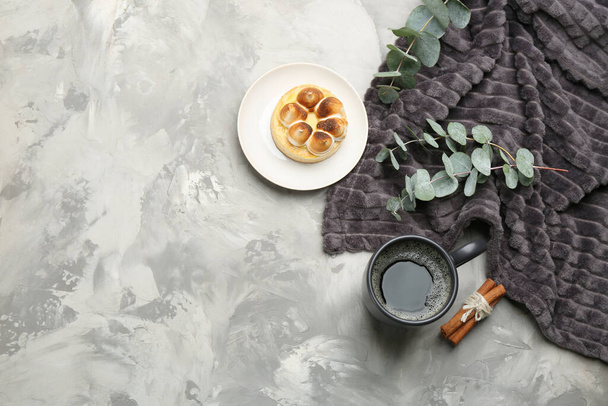 Flat lay composition with hot drink and warm plaid on grey table, space for text - Фото, изображение