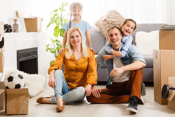 Ευτυχισμένη οικογένεια που μετακομίζει σπίτι με κουτιά τριγύρω - Φωτογραφία, εικόνα