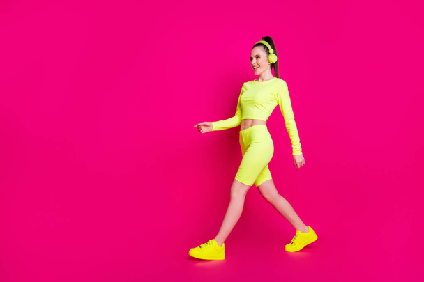 Full length body size view of her she nice attractive charming slender sporty cheerful girl listening pop rock melody music walking isolated bright vivid shine vibrant pink fuchsia color background - Valokuva, kuva