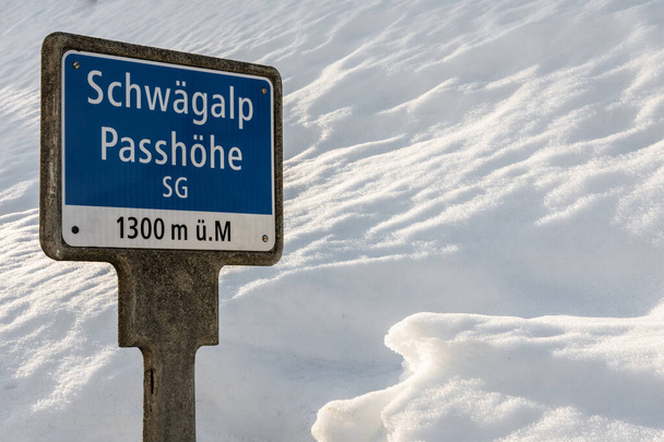 Знак з висотою покажчик на найвищій точці Шваегальп прохідної дороги взимку, Кантон Стен Галлен, Швейцарія. - Фото, зображення