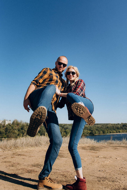 Chico y chica en camisas enjauladas y zapatos de trekking en rocas de granito - Foto, imagen