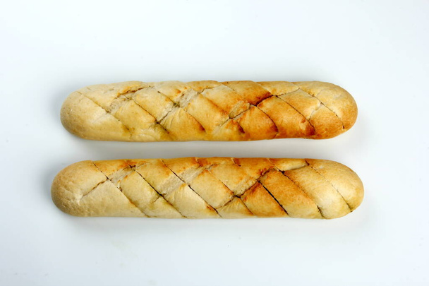 Dwa chrupiące plasterki francuskiego chleba nadziewane ziołami, masłem i czosnkiem. Odizolowany na białym tle. Pieczone bagietki czosnkowe izolowane na białym tle - Zdjęcie, obraz