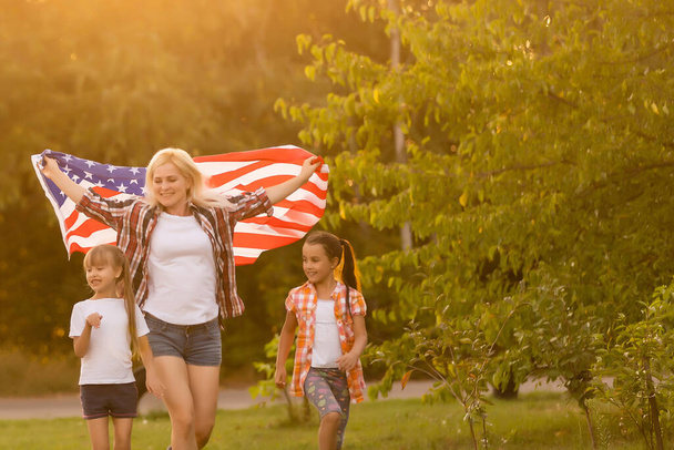 Family Posing Outdoors With American Flag - Photo, Image