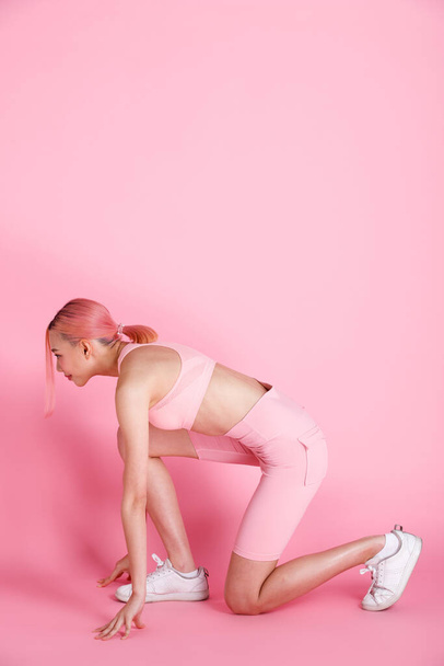 20s Asian Woman pink dying hair, sport bra short pant and shoes. Female girl exercise yoga, fitness in concept of Sweat Strong Success Women over pink tone Background isolated copy space - 写真・画像