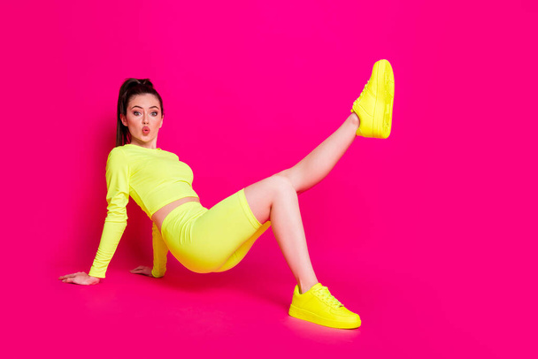 Full length body size photo of cheerful sportswoman exercising keeping leg up sending air kiss isolated on bright pink color background - Valokuva, kuva