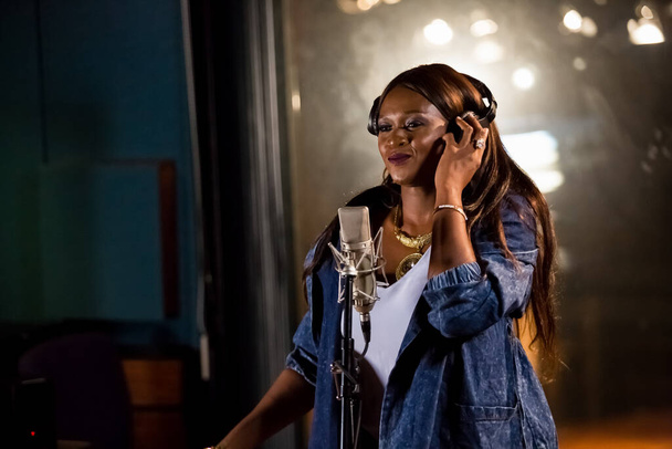 Johannesburg, South Africa - April 29, 2015: Waje Nigerian singer recording vocal part on Afro-pop song in studio - Photo, Image