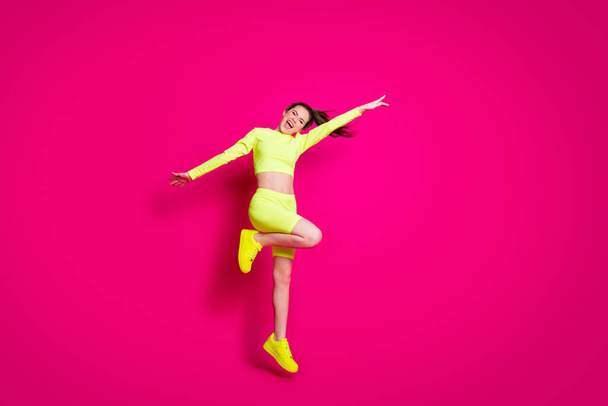 Full length body size photo of jumping sportswoman laughing cheerfully wearing stylish sportswear isolated on bright pink color background - Foto, Imagem