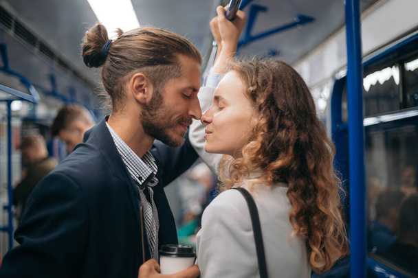 man and woman in love looking at each other on a subway train. - Фото, зображення