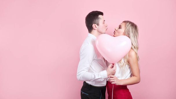 Valentines day. Beautiful romantic couple with heart balloon on pink background - Foto, Imagem