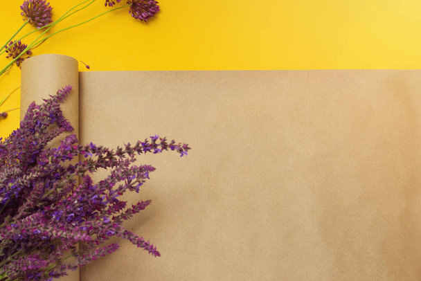 A bouquet of lavender flowers and craft paper for floristry on a bright yellow background. Baner for the florist. View from above. Horizontal format. Place for text. - Fotoğraf, Görsel