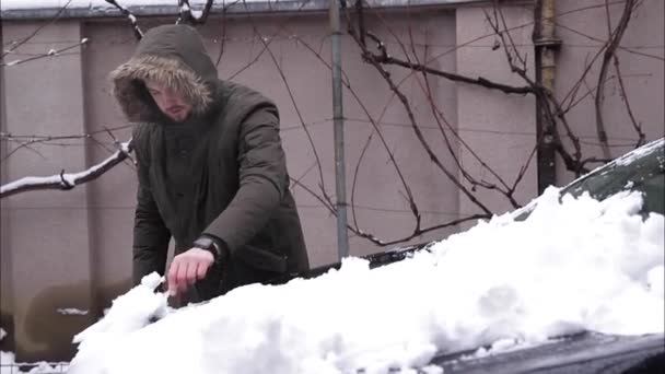 男は車から降りて雪玉を作る - 映像、動画