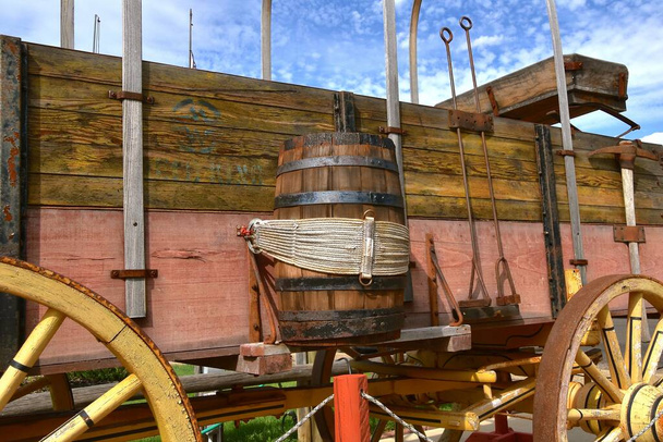 Un viejo vagón cubierto de madera con un barril de agua atado a un lado - Foto, Imagen