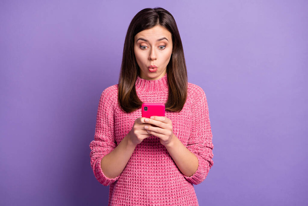 Photo portrait of amazed girl browsing internet social media cellphone isolated on vivid violet color background - 写真・画像