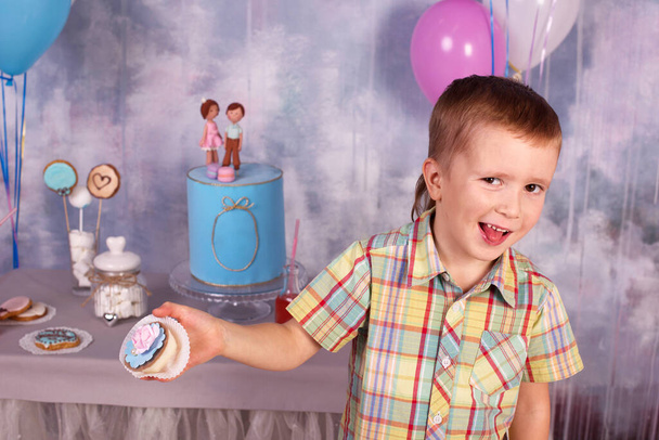 Happy boy eat sweet cream cake on birthday party at home - Photo, Image
