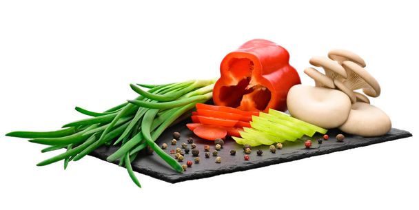 cogumelos ostra, cebolas verdes e dois pimentos vermelhos e verdes frescos, cortados em anéis em uma placa preta feita de ardósia natural. - Foto, Imagem