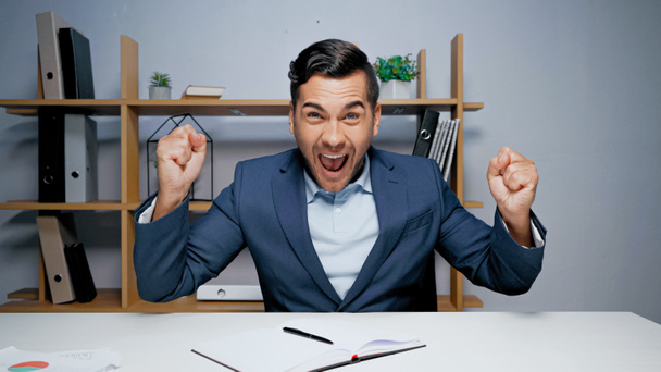 Aufgeregter Geschäftsmann zeigt Ja-Geste bei Videochat im Büro  - Foto, Bild