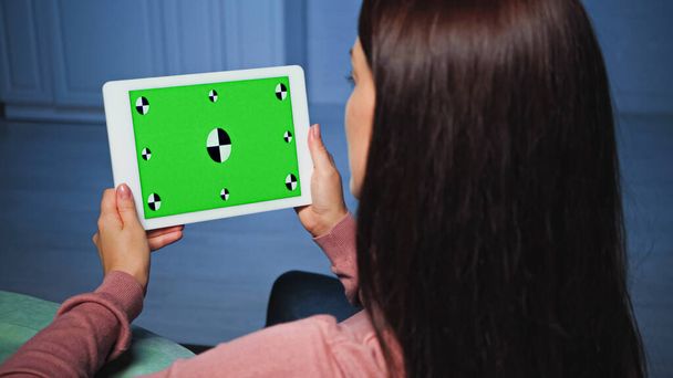 Tablette numérique avec clé chromatique dans les mains de la femme au premier plan flou  - Photo, image