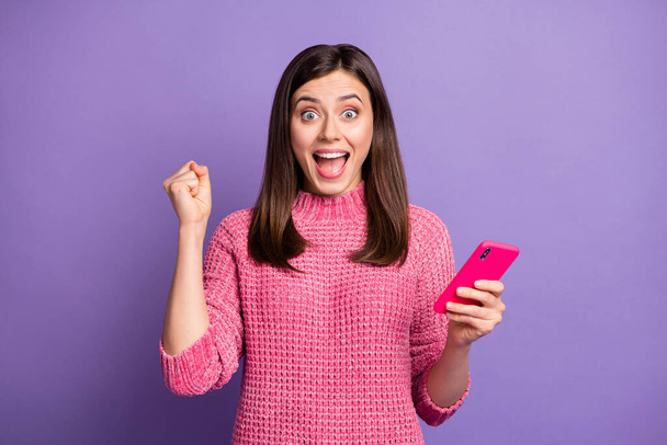 Photo portrait of happy female brunette gesturing like winner overjoyed isolated on vibrant purple color background - Photo, Image