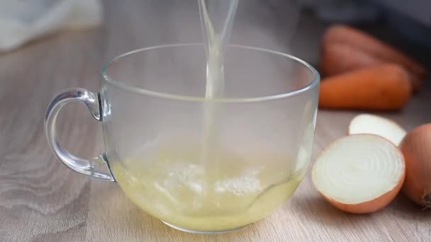 Hot chicken broth is poured into a glass cup. - Footage, Video