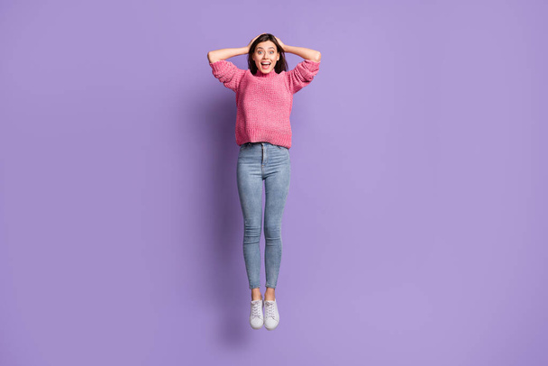 Full length body size photo of jumping high amazed surprised woman touching head isolated on bright purple color background - Photo, Image